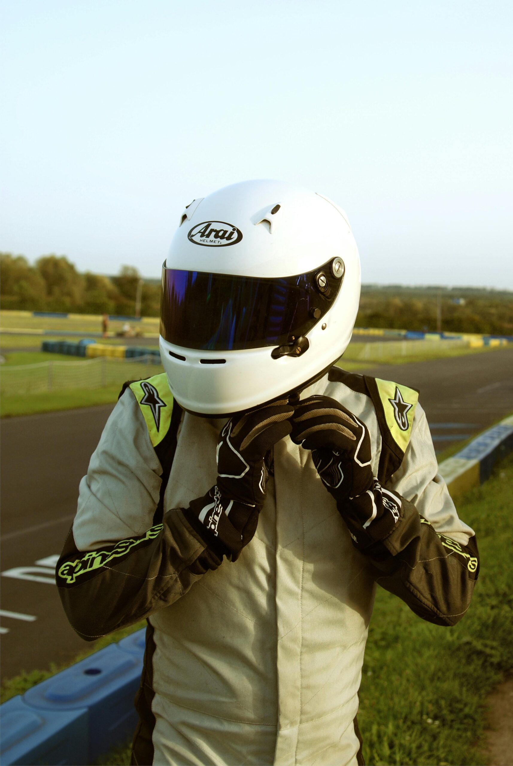 Karting racer adjusting helmet on race track in Sotteville-Sous-le-Val, France.