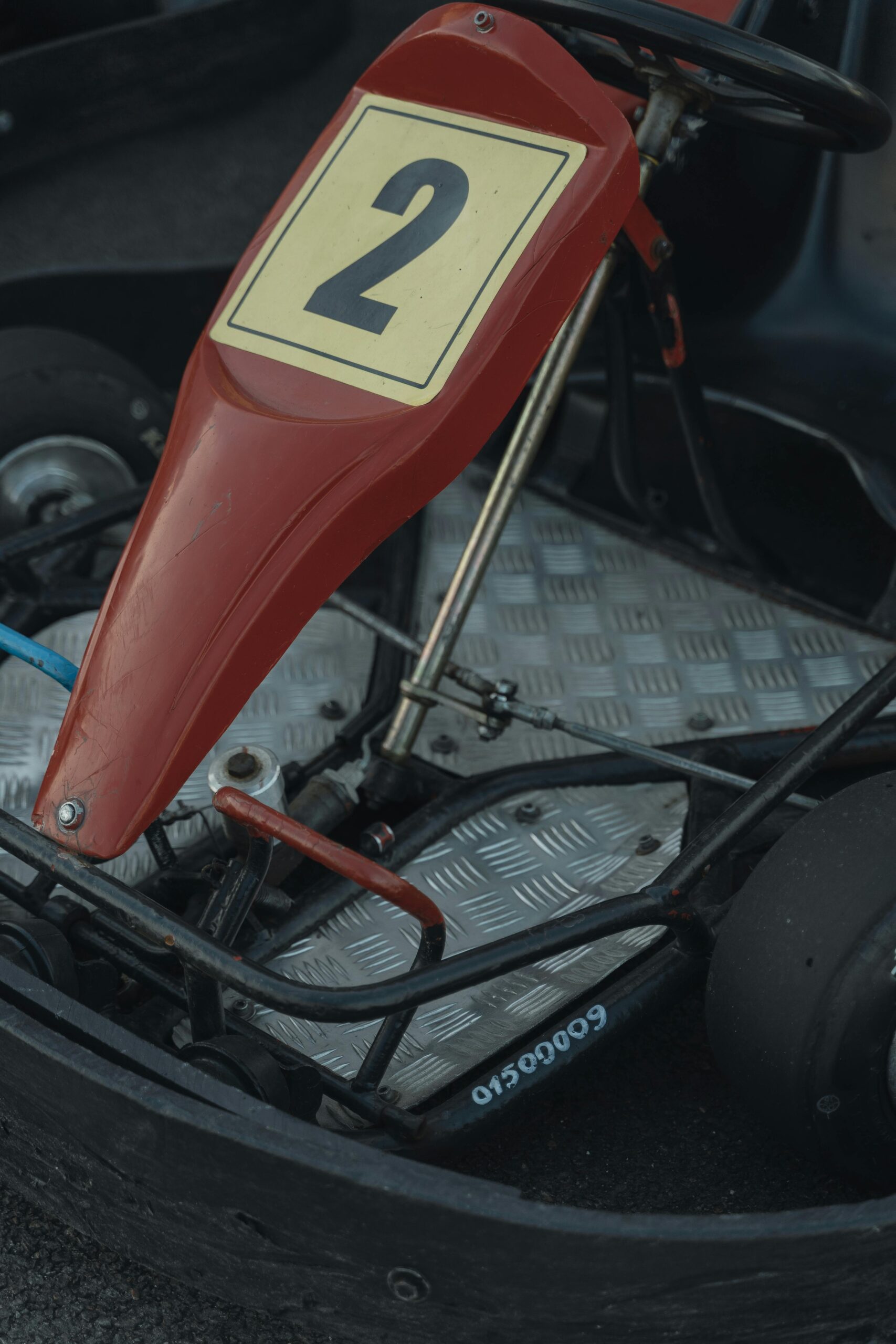 A detailed view of a red go-kart with a yellow number two, focusing on its structure and design.